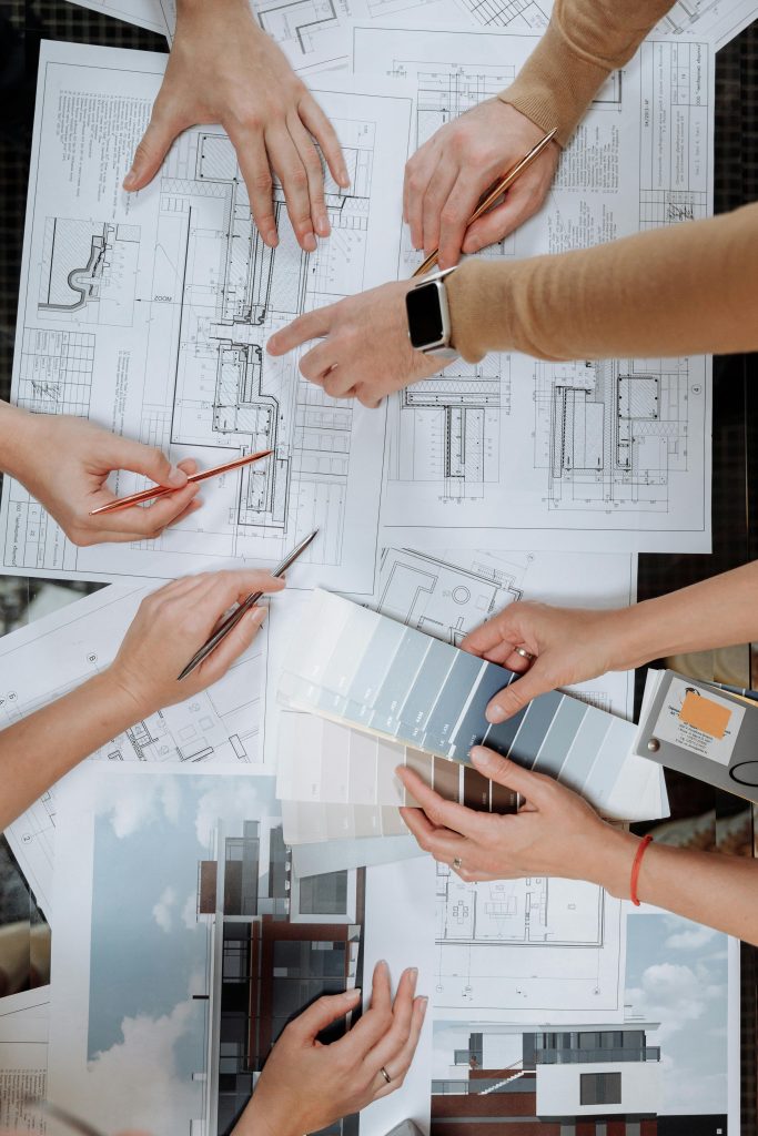 Team working together on architectural blueprints and color swatches.